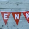 Slinger voor Fenna in oranje met witte letters.