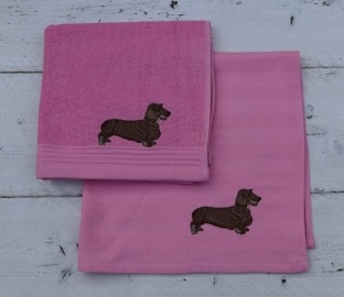 Roze keukenhanddoek en theedoek met een ruwharige teckel
